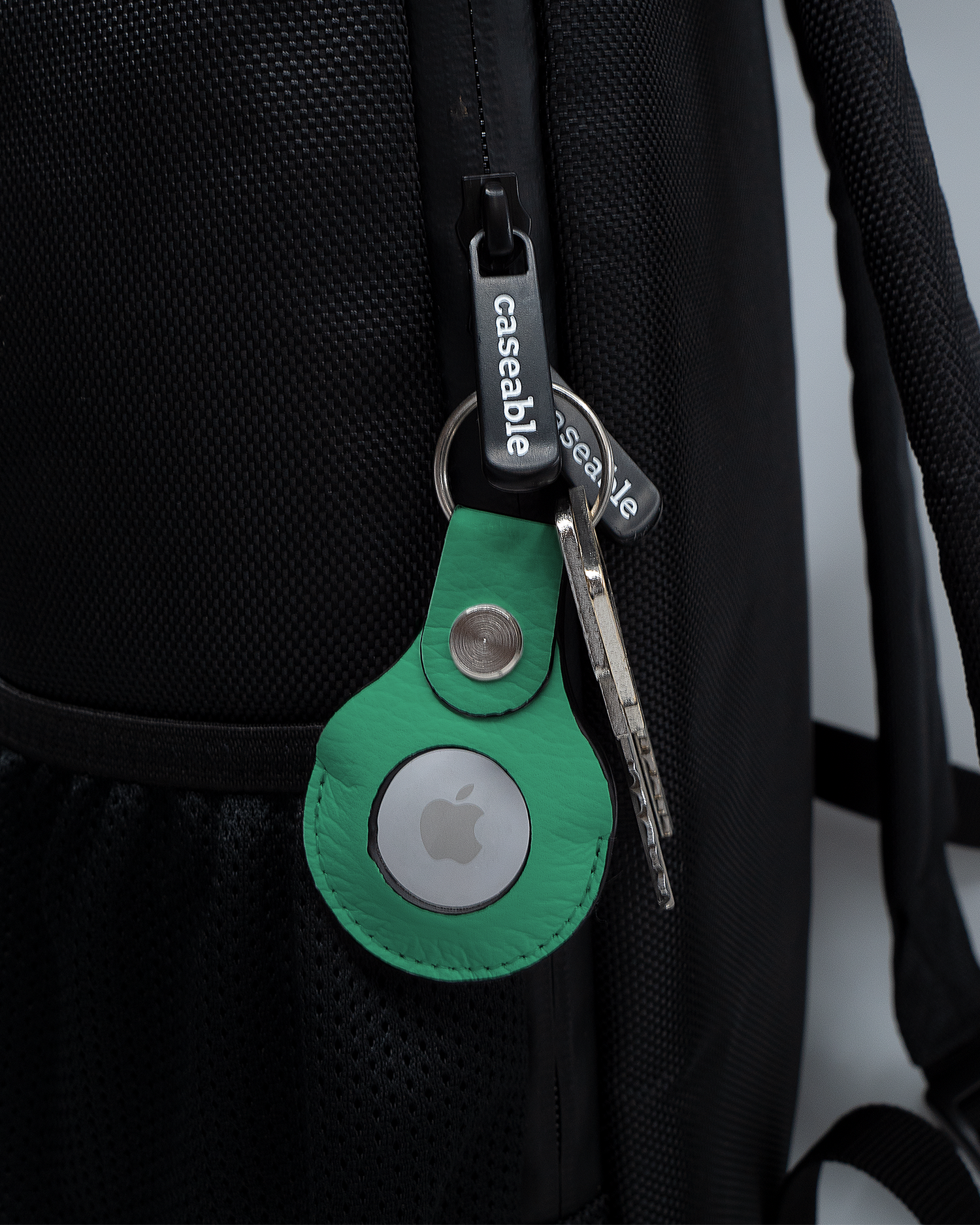 AirTag Anhänger mit Motiv ISG Neon Green an einem Rucksack agebracht