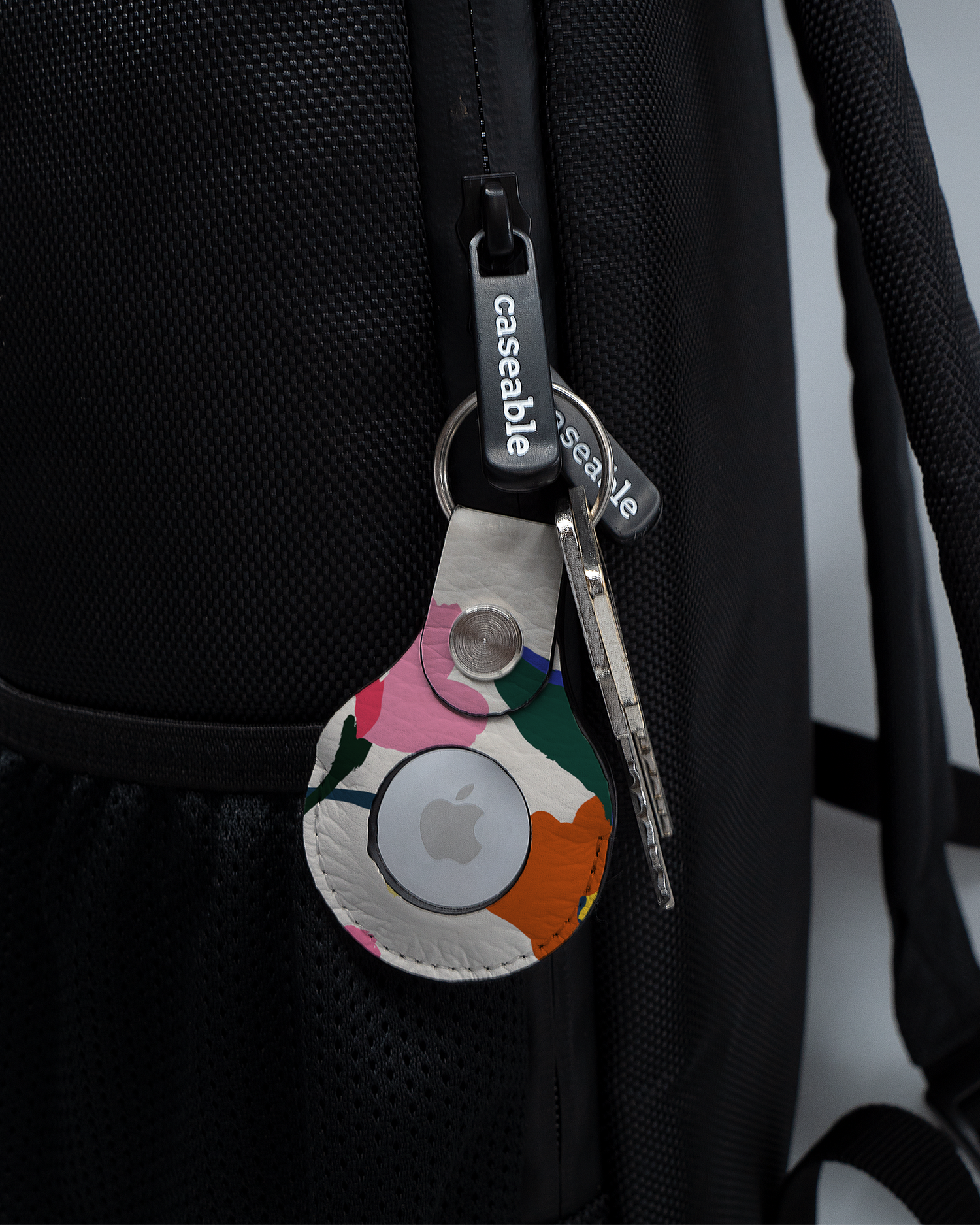 AirTag Anhänger mit Motiv Handpainted Blooms an einem Rucksack agebracht