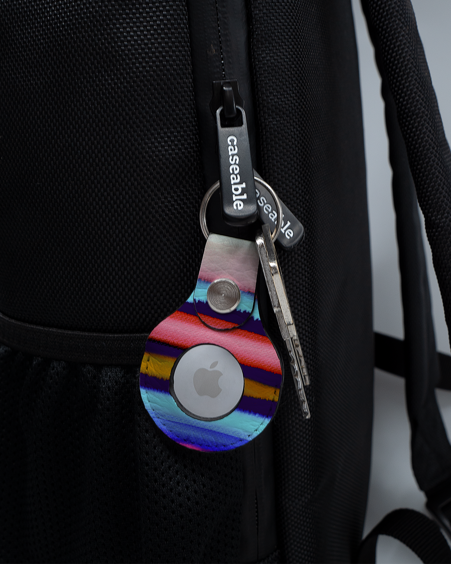 AirTag Anhänger mit Motiv Watercolor Stripes an einem Rucksack agebracht