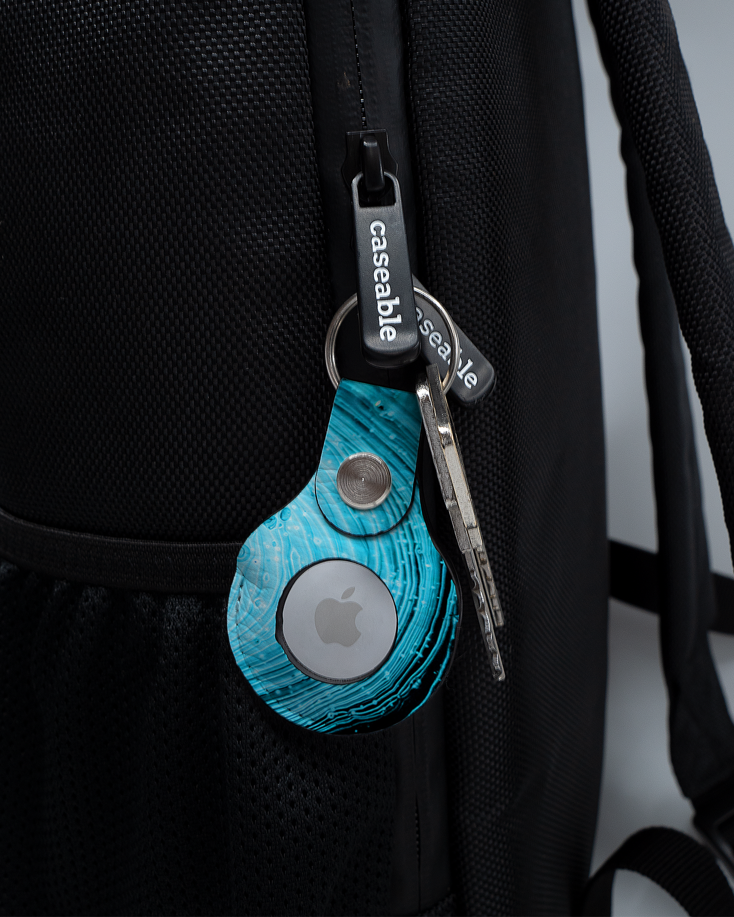 AirTag Anhänger mit Motiv Turquoise Ripples an einem Rucksack agebracht