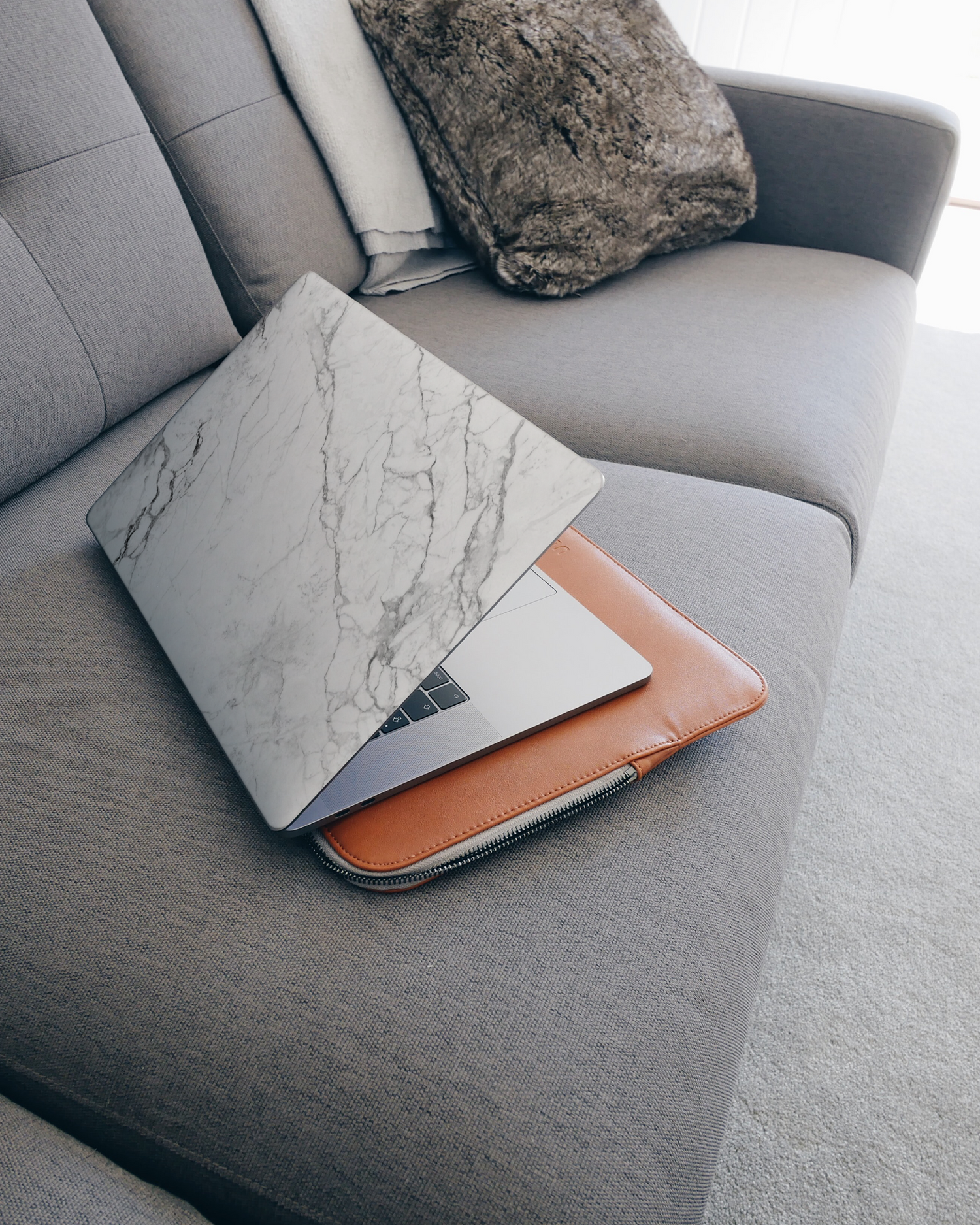 White Marble Laptop Aufkleber für 15 Zoll Apple MacBooks auf dem Sofa