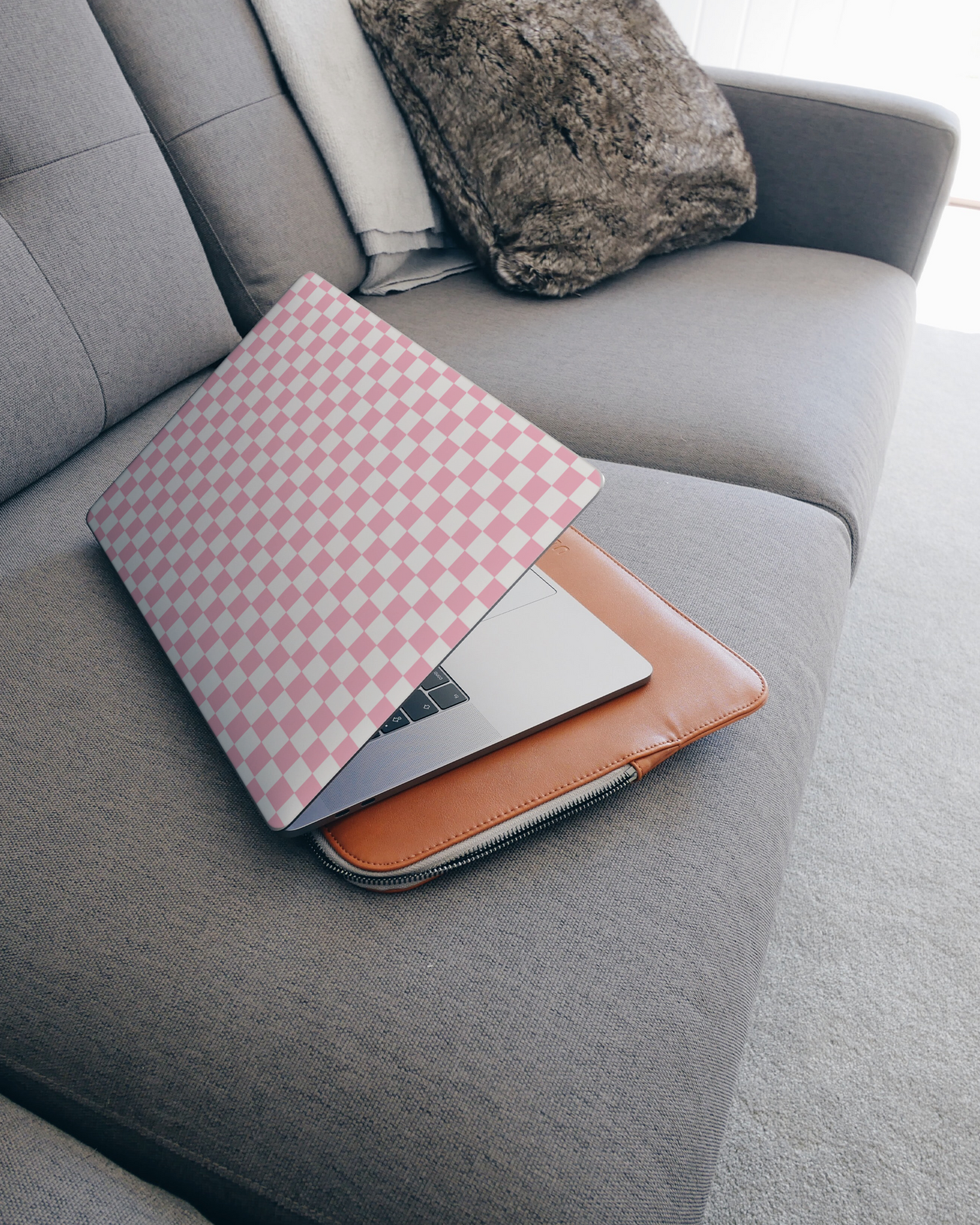 Pink Checkerboard Laptop Aufkleber für 15 Zoll Apple MacBooks auf dem Sofa
